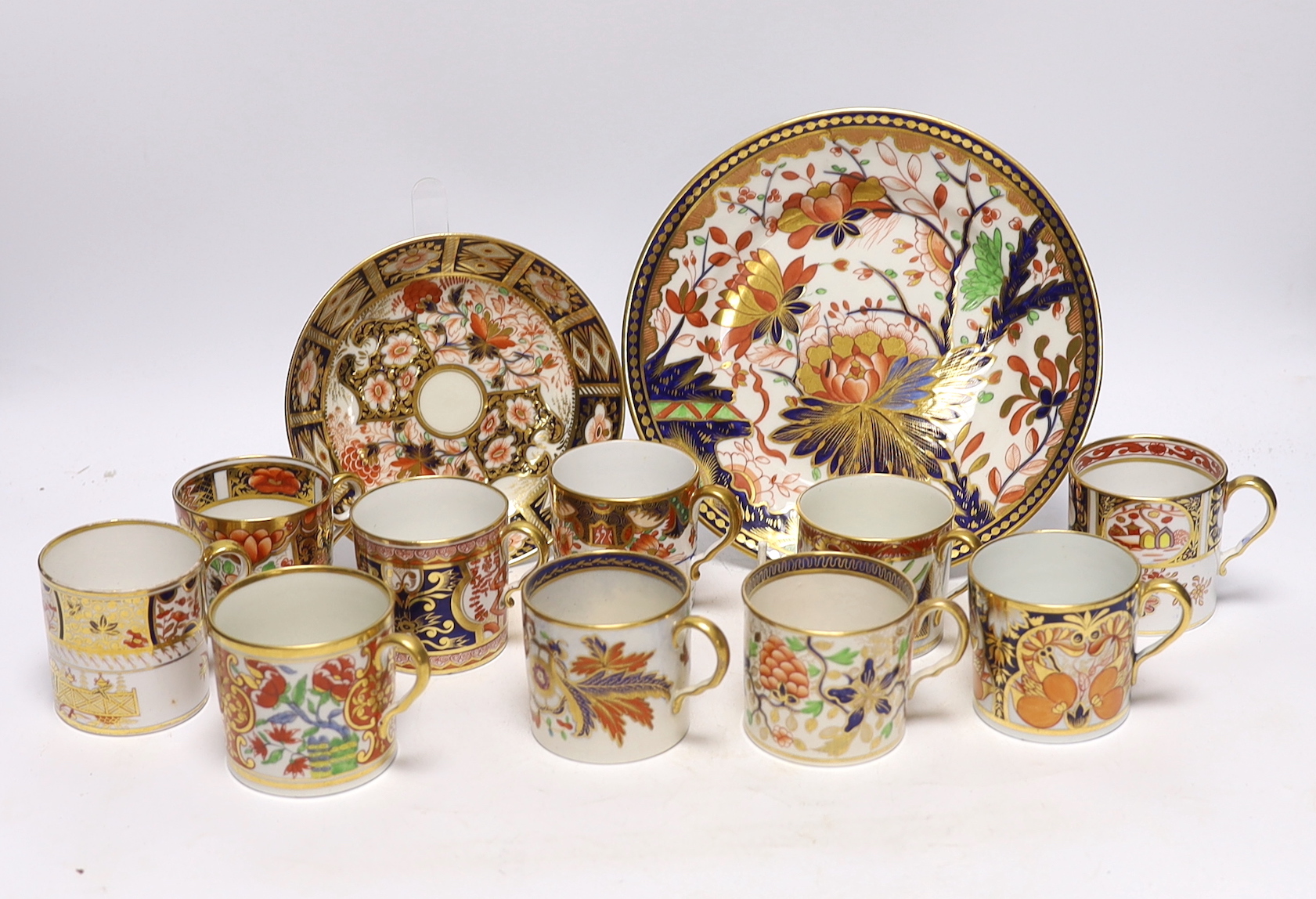 Ten 1800-1820 English porcelain coffee cans, including Imari pattern examples, one with matching saucer, together with a side plate (12)